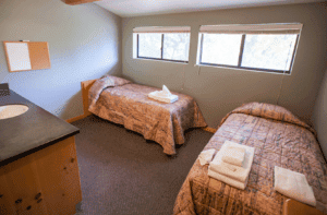 Room with beds in it and two windows with a vanity sink