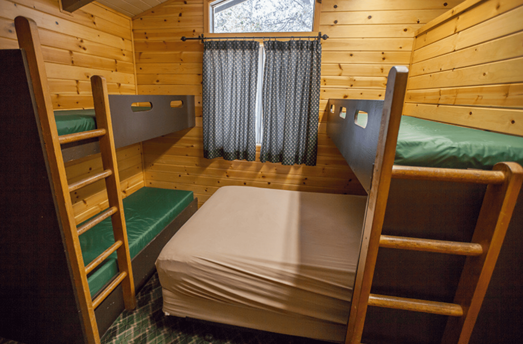 Room in cabin with bunk beds and a large queen bed