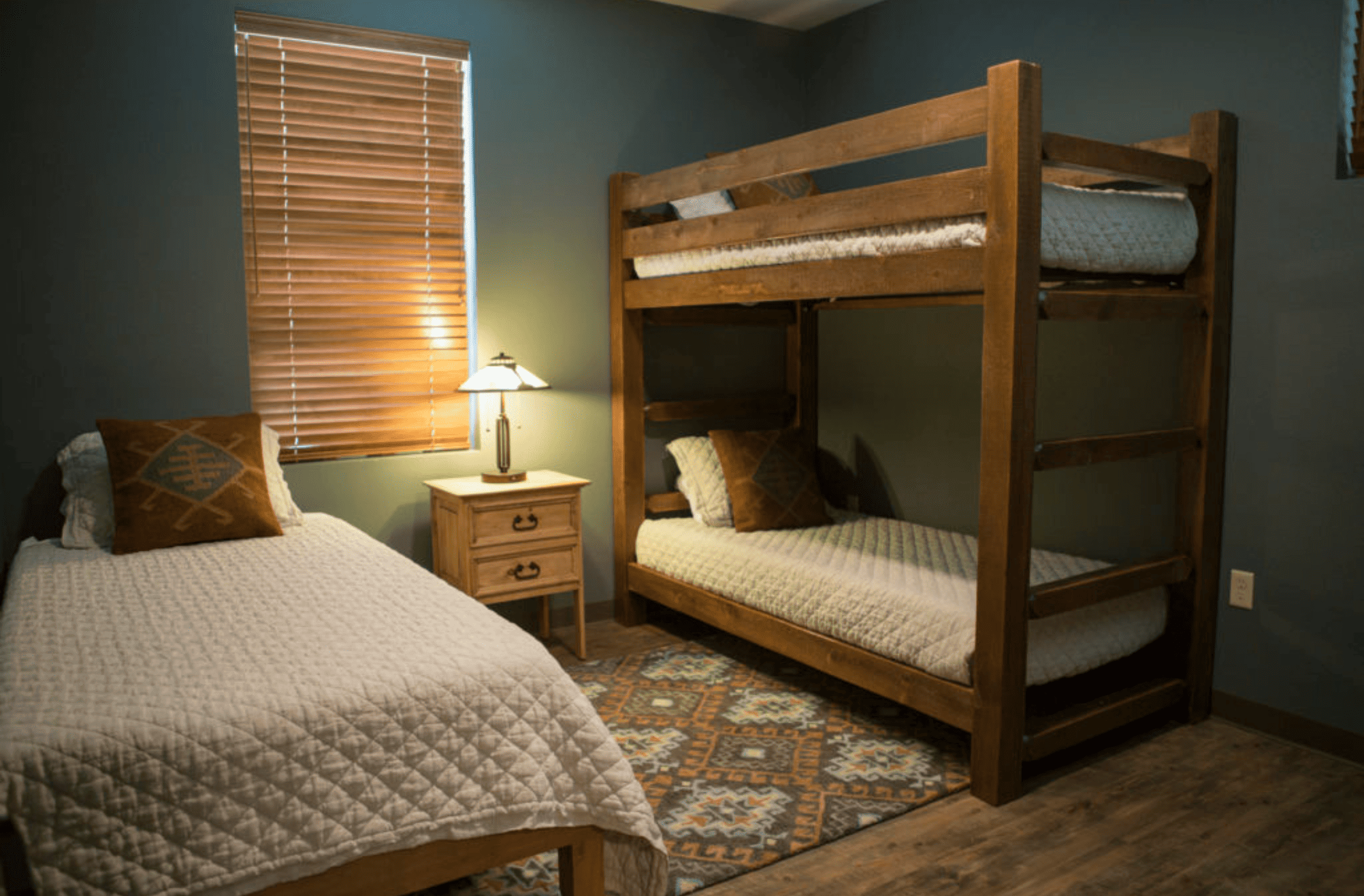 bedroom with queen size bed and two bunk beds with a nightstand in the middle